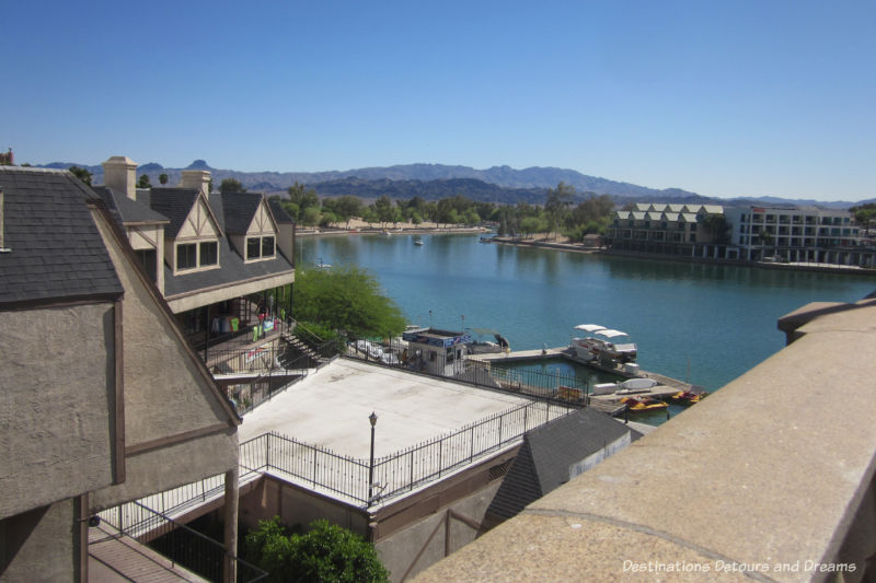 View of lake with buildings along sides and mountains in background