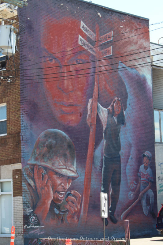 Murals in shade of red, grey, and purple showing actor Adam Beach as himself and as some of his roles