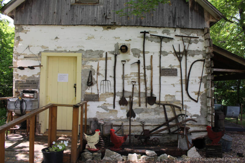 Museum pioneer home with handmade tools hanging on outside wall 