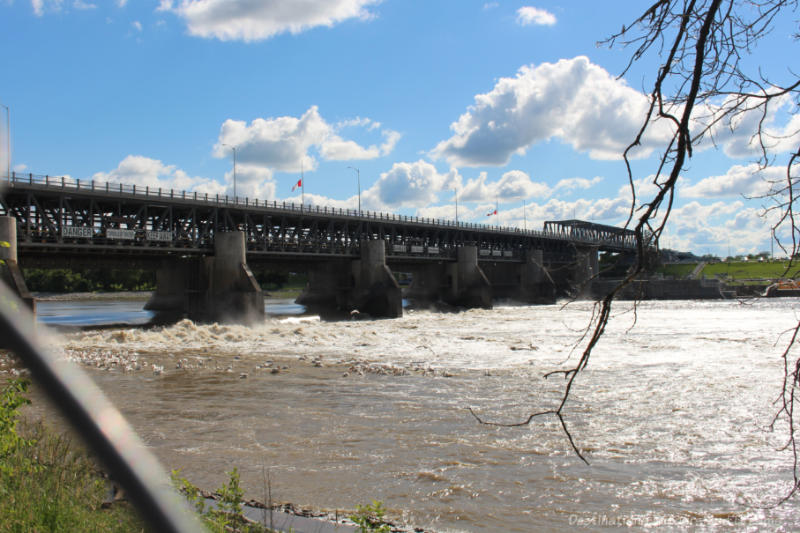 Bridge, dam, and locks over a river with water rushing through