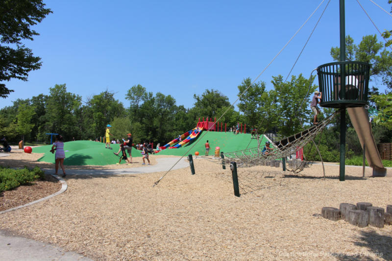 Playground area with net climbing structures, fake hills, and slides