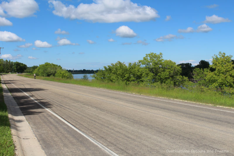 Cyclist on scenic roadway beside the river