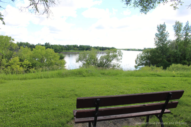 Grassy area with a park bench overlooking a river