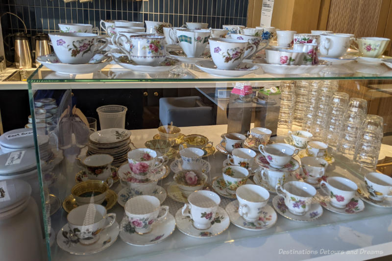 Display of china teacups and saucers in assorted patterns at a bistro