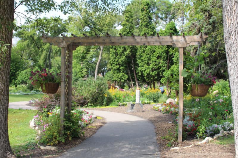 Arbor over walkway leading to a garden in a park