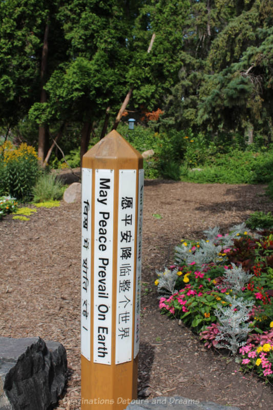 Pole in garden engraved with May Peace Prevail On Earth