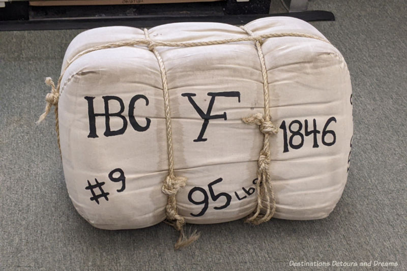 A bale of fur covered in white cloth and bound with thick twine