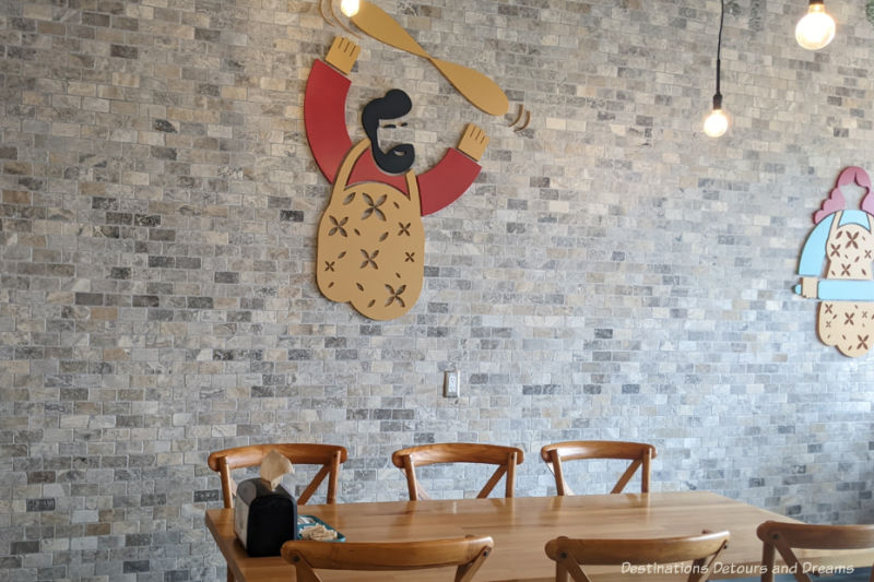 table at a restaurant with a brick wall behind and wooden bearded chef figure on wall