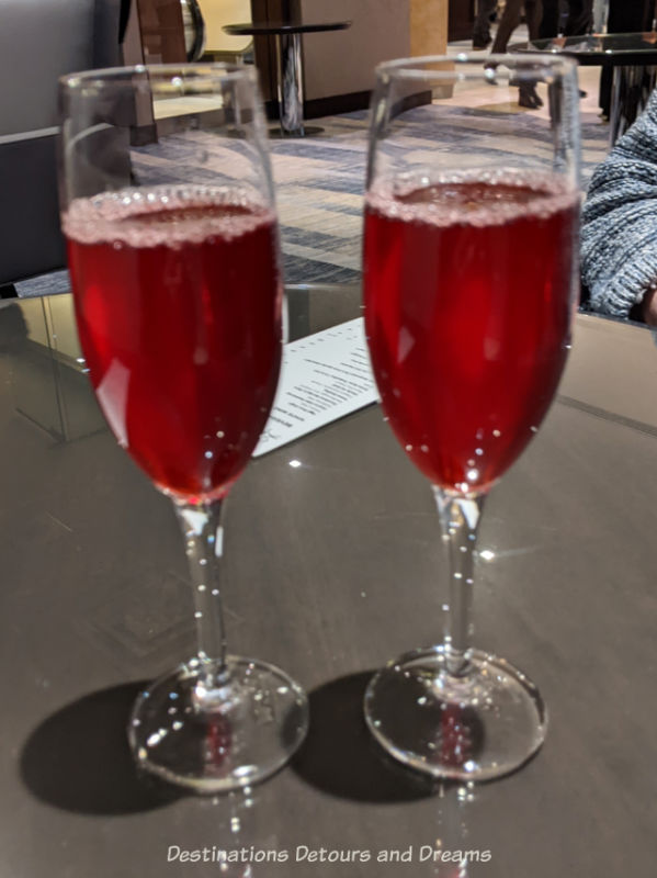 Two champagne glasses containing a reddish beverage