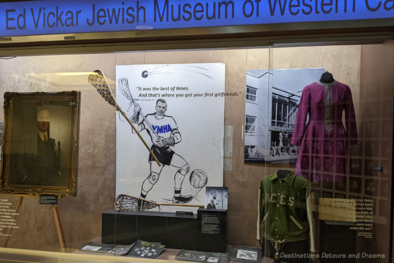 Large display window into museum exhibit containing costumes, photographs, and a lacrosse player poster