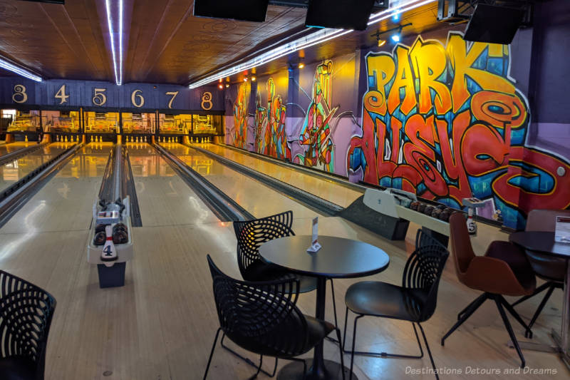 Bowling lanes with a vibrant coloured mural of musical instruments along side wall