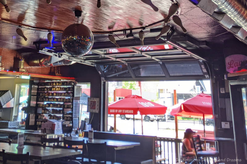 restaurant tables with open garage door at its front leading to a sidewalk patio