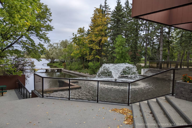 concrete patio area overlooking pond and fountain and green space